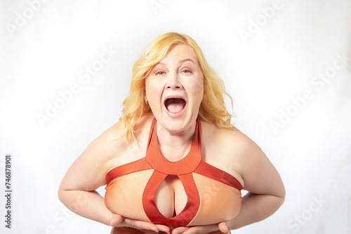 A fat middle-aged woman with a size five breast is showing it off. Health difficulties with large breasts. Plastic surgery