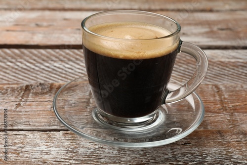 Cup of aromatic coffee on wooden table, closeup