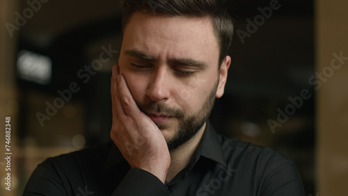 Unhealthy sick Caucasian guy businessman man has toothache oral illness problem with hygiene teeth caries feel dental ache discomfort suffer aching toothy pain sensitive tooth touching inflamed cheek