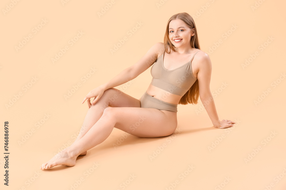 Beautiful woman in underwear on beige background