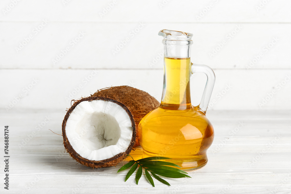 Decanter of coconut cosmetic oil on white wooden background Decanter of coconut cosmetic oil on white wooden background