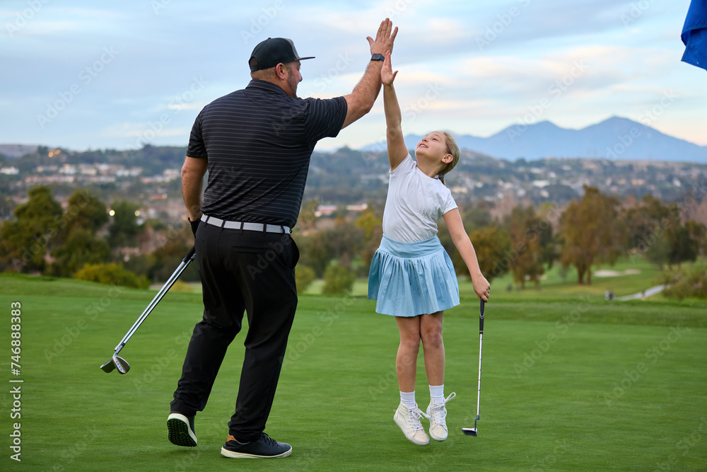 Obraz premium A father and Daughter play golf on a golf course