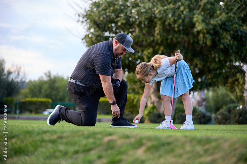 Obraz premium A father and Daughter play golf on a golf course