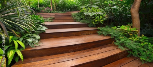 A set of wooden steps in a lush tropical garden, providing a practical solution for navigating the outdoor space. The steps are crafted from timber planks, adding a touch of elegance to the natural