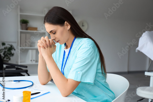 Female nurse praying at tab...