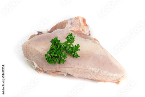 A single raw bone-in chicken breast with a parsley garnish isolated on white