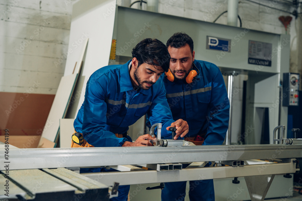Obraz premium Contemporary Carpenter Working in factory, operating modern machines. Portrait of modern carpenter making wood furniture at industrial job site.