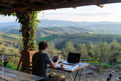 A person working on a laptop in a scenic outdoor cafe
