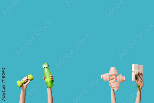 Female hands with dumbbells, bottle of water and gift box for International Women's Day on color background