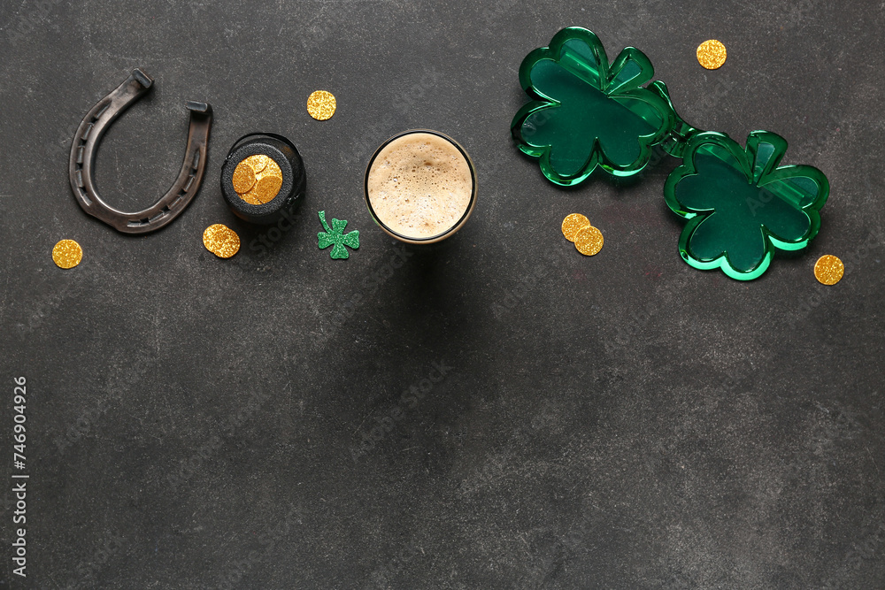 Glass of dark beer with plastic eyeglasses, horseshoe and pot of golden coins for St. Patrick's Day celebration on black grunge background - obrazy, fototapety, plakaty 