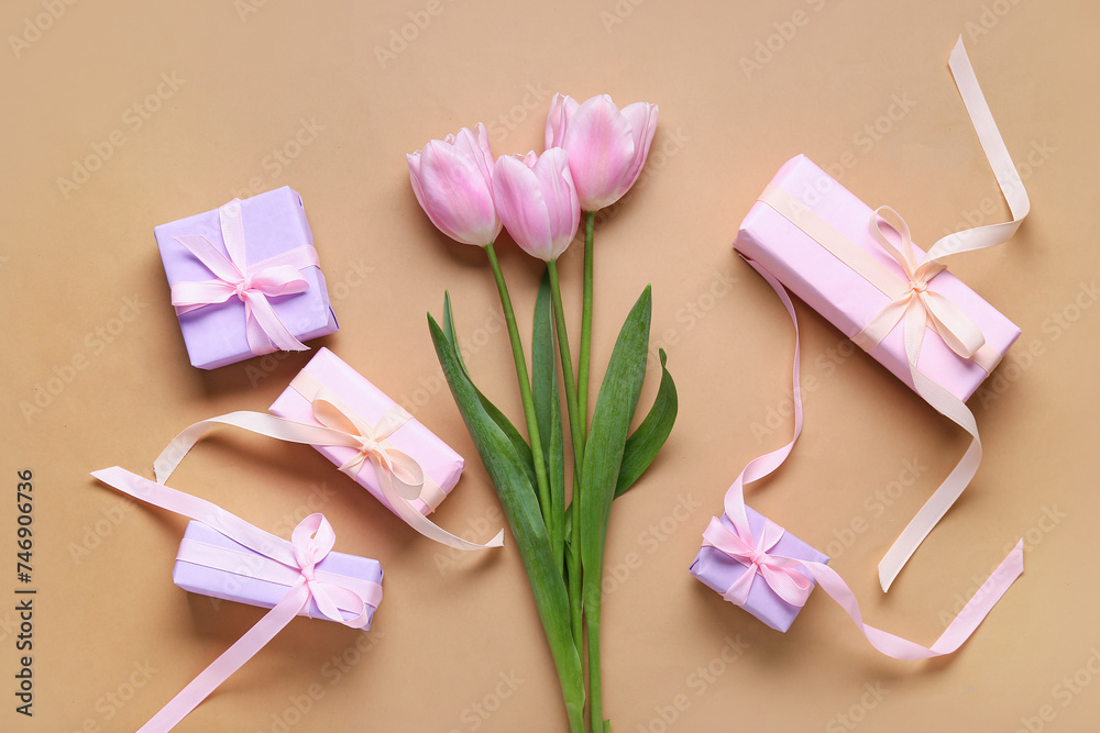 Composition with gift boxes and pink tulips on beige background. Top view Composition with gift boxes and pink tulips on beige background. Top view