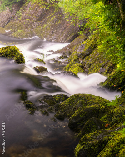 Beautiful cascading waterfall through a lush green landscape - Rhaeadr Ewynnol / Swallow Falls in Betws y Coed, North Wales photo