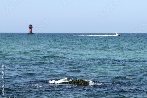 Seascape with a lighthouse and a boat
