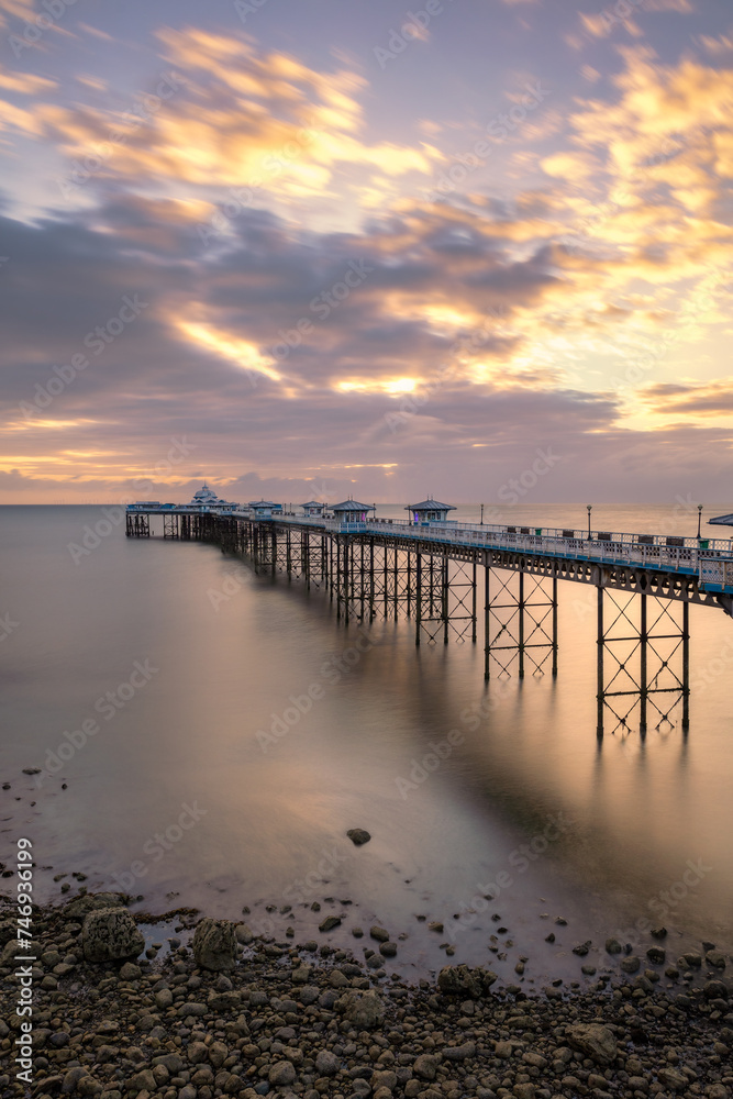 Sunrise golden light over Llandudno Pier in the Victorian seaside resort in North Wales, United Kingdom