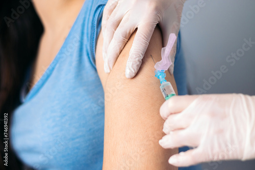 Vaccine in injection needle. Doctor working with patient's arm. Physician or nurse giving vaccination and immunity to virus, influenza or HPV with syringe. Appointment with medical expert. Close-up photo