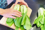 Green bok choy on a cutting board in a kitchen