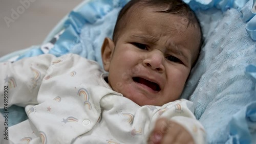 Distressed six month old Asian Indian baby expresses attention with crying MEDIUM SHOT photo