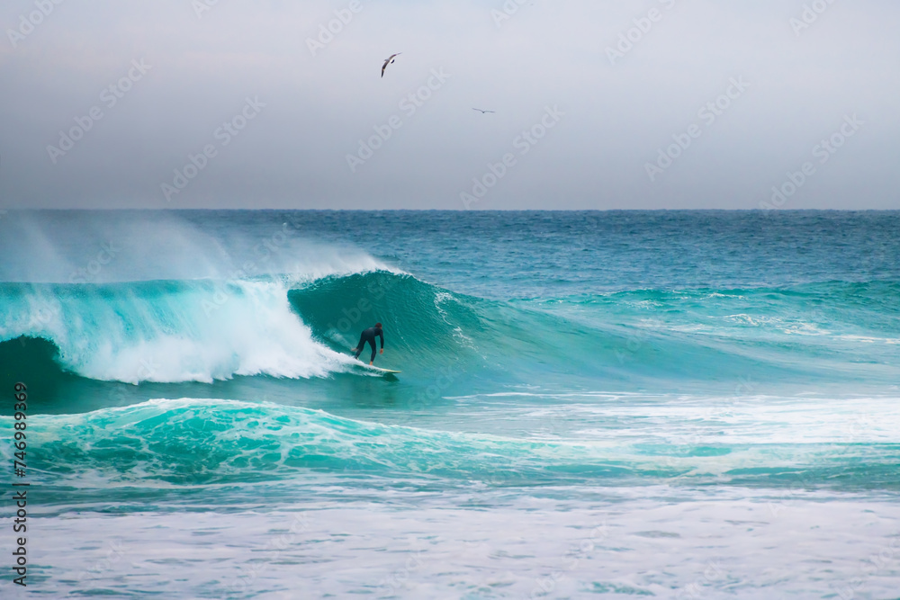 Fototapeta premium Surfer riding big waves in Nazare, Portugal. Big waves of Atlantic ocean in winter season