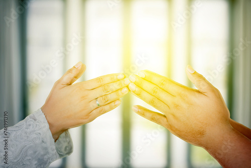 Male and female hands greeting one another on Ramadan Mubarak Holiday