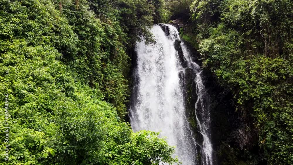 Lush greenery surrounds a cascading waterfall in Baños, Ecuador, serene natural setting Lush greenery surrounds a cascading waterfall in Baños, Ecuador, serene natural setting