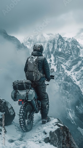 man motorcyclist standing near her enduro motorcycle on snowy mountain top, snow peaks skyline view, high beautiful mountains