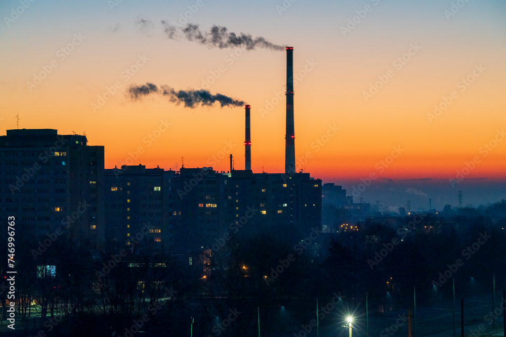 Fototapeta premium View across the Poland City of Tychy with two chimneys with a sunrise background