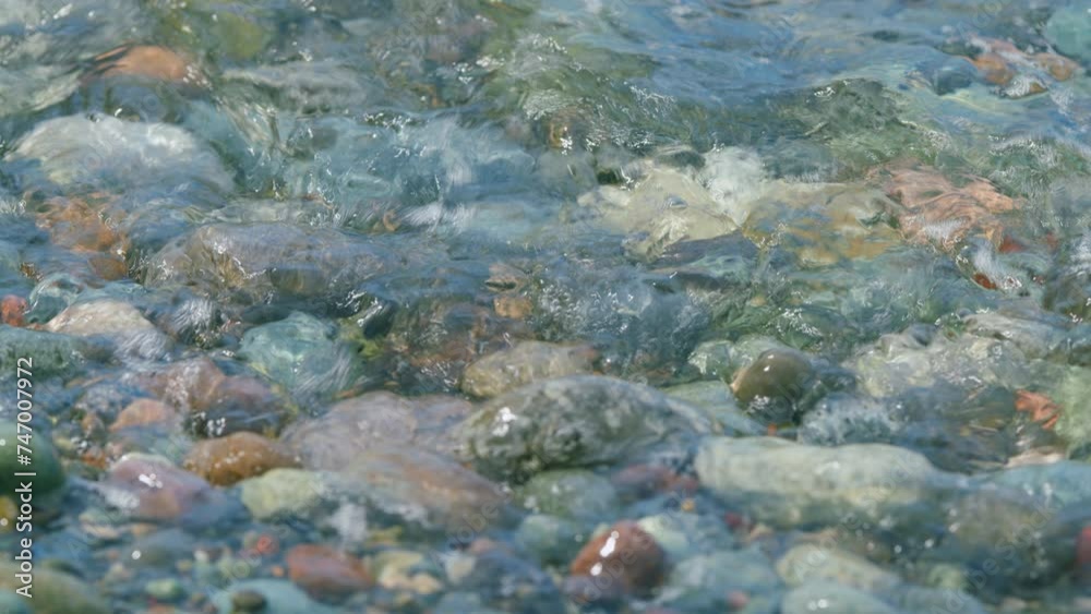 Sea Stones Are Visible Through Clear Water Of Waves. Pebbles On The Seashore. Sea Stones Are Visible Through Clear Water Of Waves. Pebbles On The Seashore.