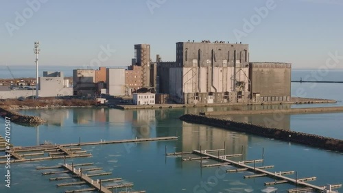 Industrial waterfront with grain elevators at Port Colborne, calm water, clear sky, no people, daylight, aerial view photo