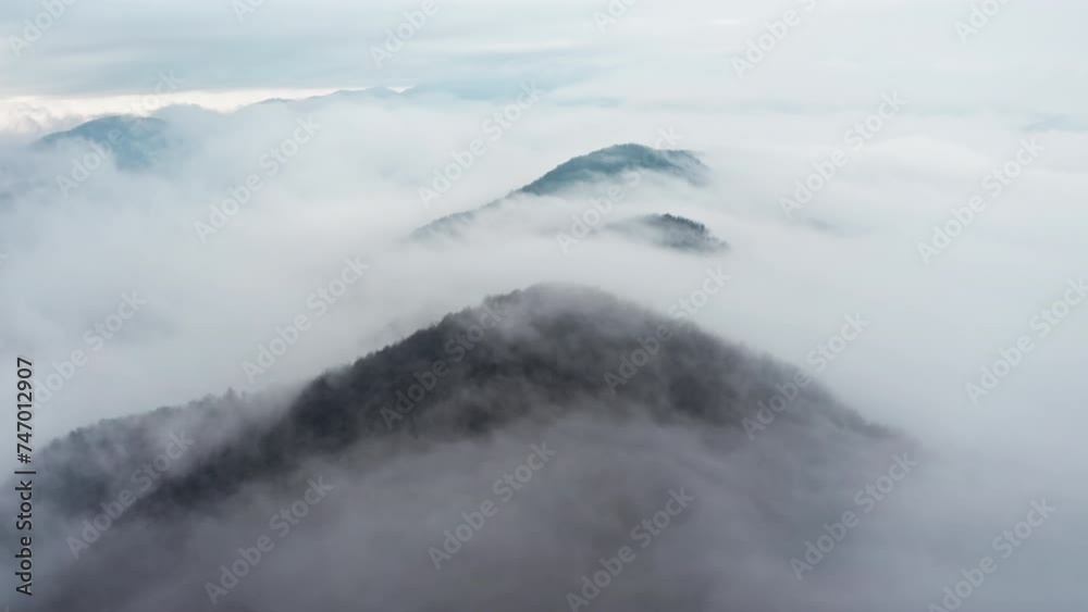 Misty mountain peaks emerging from a sea of clouds, shot during early morning Misty mountain peaks emerging from a sea of clouds, shot during early morning