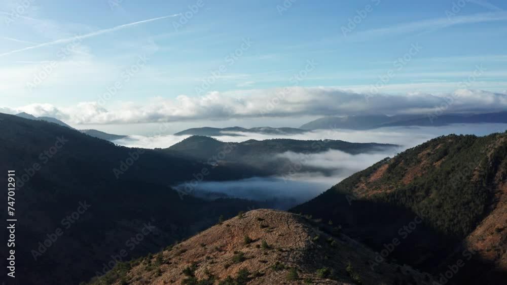Morning light bathes mountainous landscape, with valleys shrouded in mist and a clear blue sky overhead, a serene aerial view Morning light bathes mountainous landscape, with valleys shrouded in mist and a clear blue sky overhead, a serene aerial view