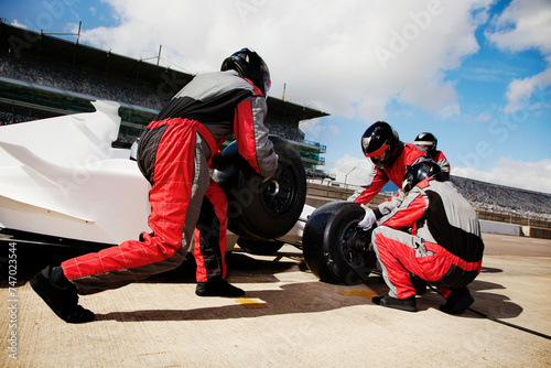 Pit crew in synchronized action during a highspeed race change 