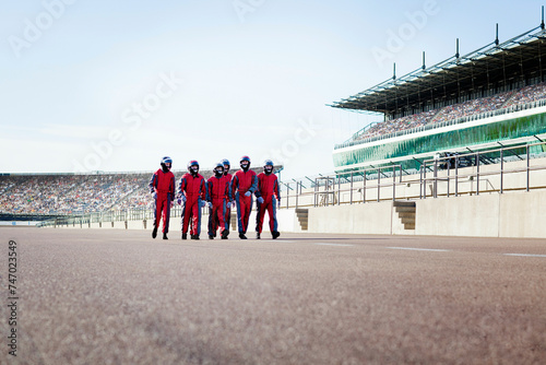Racing team poised on the track for action. Pit crew in action during a tire change at a race track.  