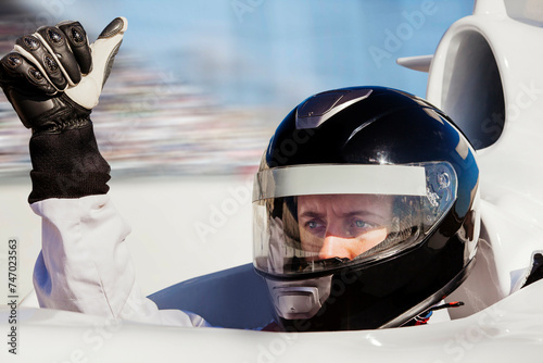 Race car driver in helmet giving a thumbsup  photo