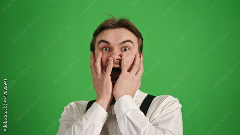 Young Man Showing Great Fear, Covering Face with Hands on Green Background Young Man Showing Great Fear, Covering Face with Hands on Green Background