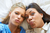 Friends, portrait and kiss face on bed for relax, fun and holiday together for connection. Women, people and mouth with emoji lips in house for bonding, happiness and memory of vacation with love