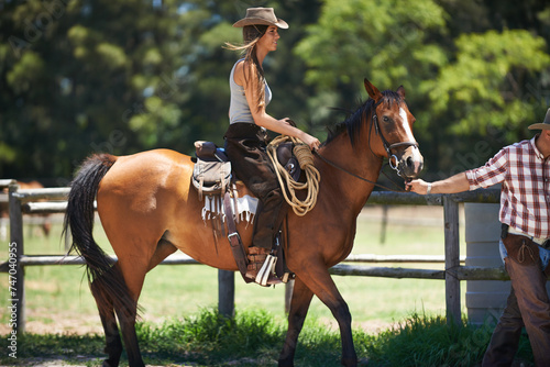 Female woman, horse and farm with cowboy, stable and ranch in Texas for pony riding. Stallion, mare and animal paddock for equestrian learning, countryside and lessons for sports for beginner rider photo