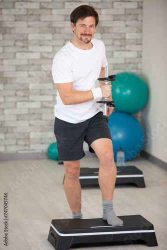 man doing step up jumps in health club photo