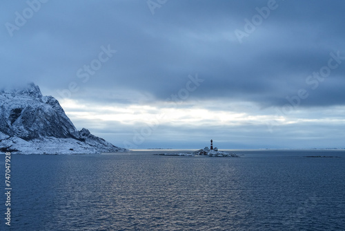 Leuchtturm und Häuser auf einer ganz kleinen Insel in den Lofoten in Norwegen