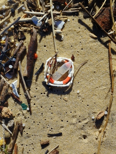 A small plastic lifebuoy as rubbish on the beach. Symbolically as a sign for save the seas