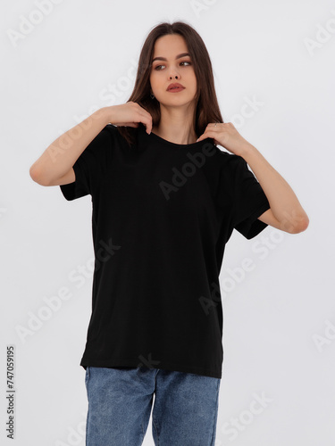 mockup of a black loose-fitting t-shirt on a young beautiful girl