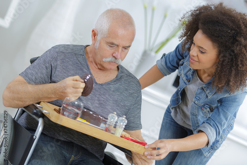 Vászonkép female carer giving a meal to senior man at home