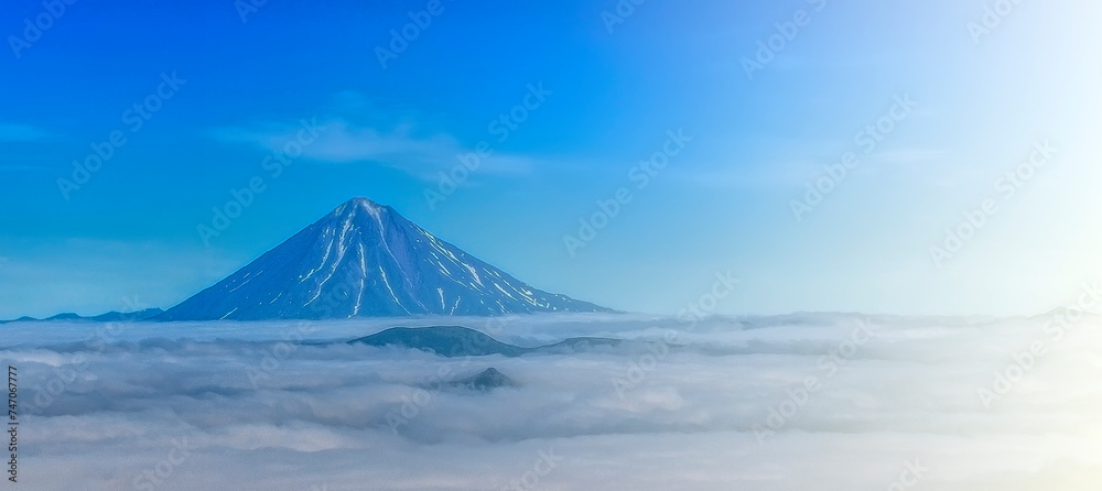 Asach volcano in the clouds in Kamchatka on soft sunlight with copy space