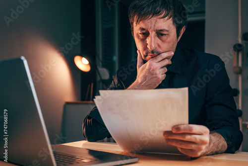 Fotografía Businessman reading paper document report in business office, exhausted adult ma