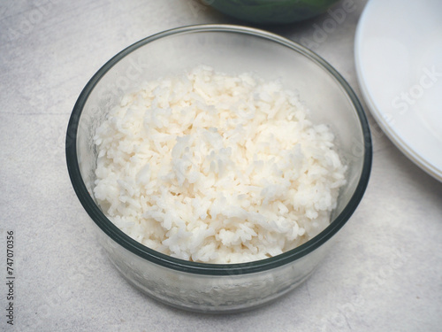 A medium bowl of steamed white rice, serve for four people, for family.
