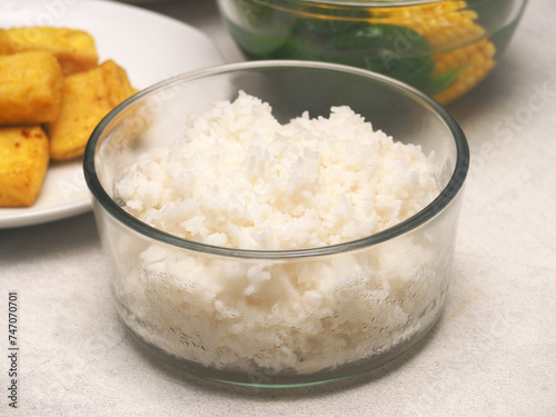 A medium bowl of steamed white rice, serve for four people, for family.
