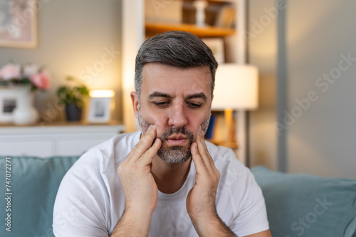 Tooth Pain And Dentistry. Young Man Suffering From Terrible Strong Teeth Pain, Touching Cheek With Hand. Feeling Painful Toothache. Dental Care And Health Concept. High Resolution