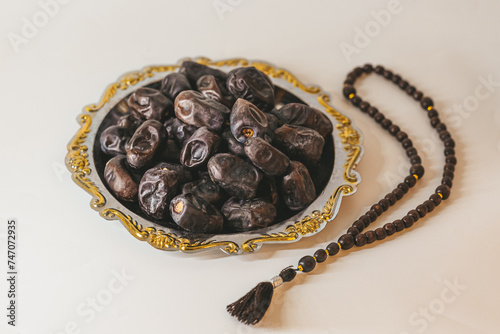 Arabian tray with dates and wooden rosary. Islamic holidays concept.