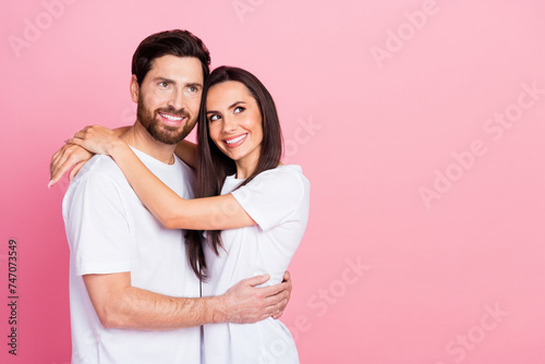 Photo portrait of attractive young couple hugging look empty space wear trendy white clothes isolated on pink color background
