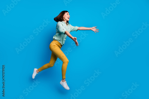 Fototapeta Naklejka Na Ścianę i Meble -  Full length photo of overjoyed woman dressed teal shirt yellow trousers run to empty space catch object isolated on blue color background
