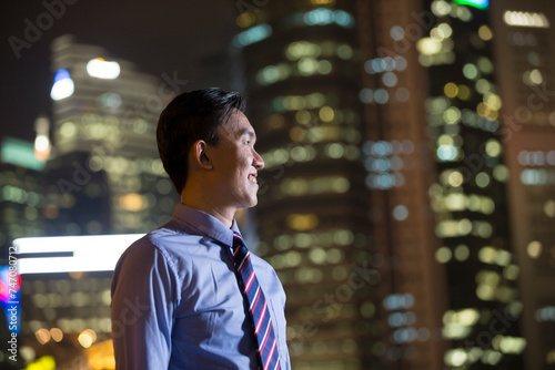Photography Chinese businessman standing outdoors at night.